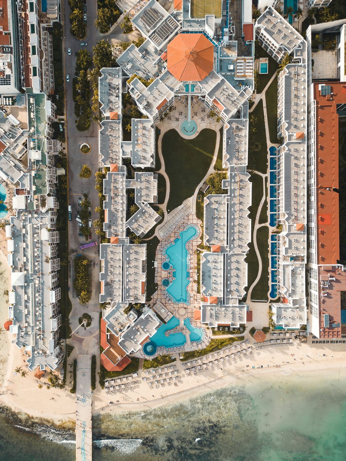 Vista aérea de un desarrollo con alberca frente al mar en Cancún